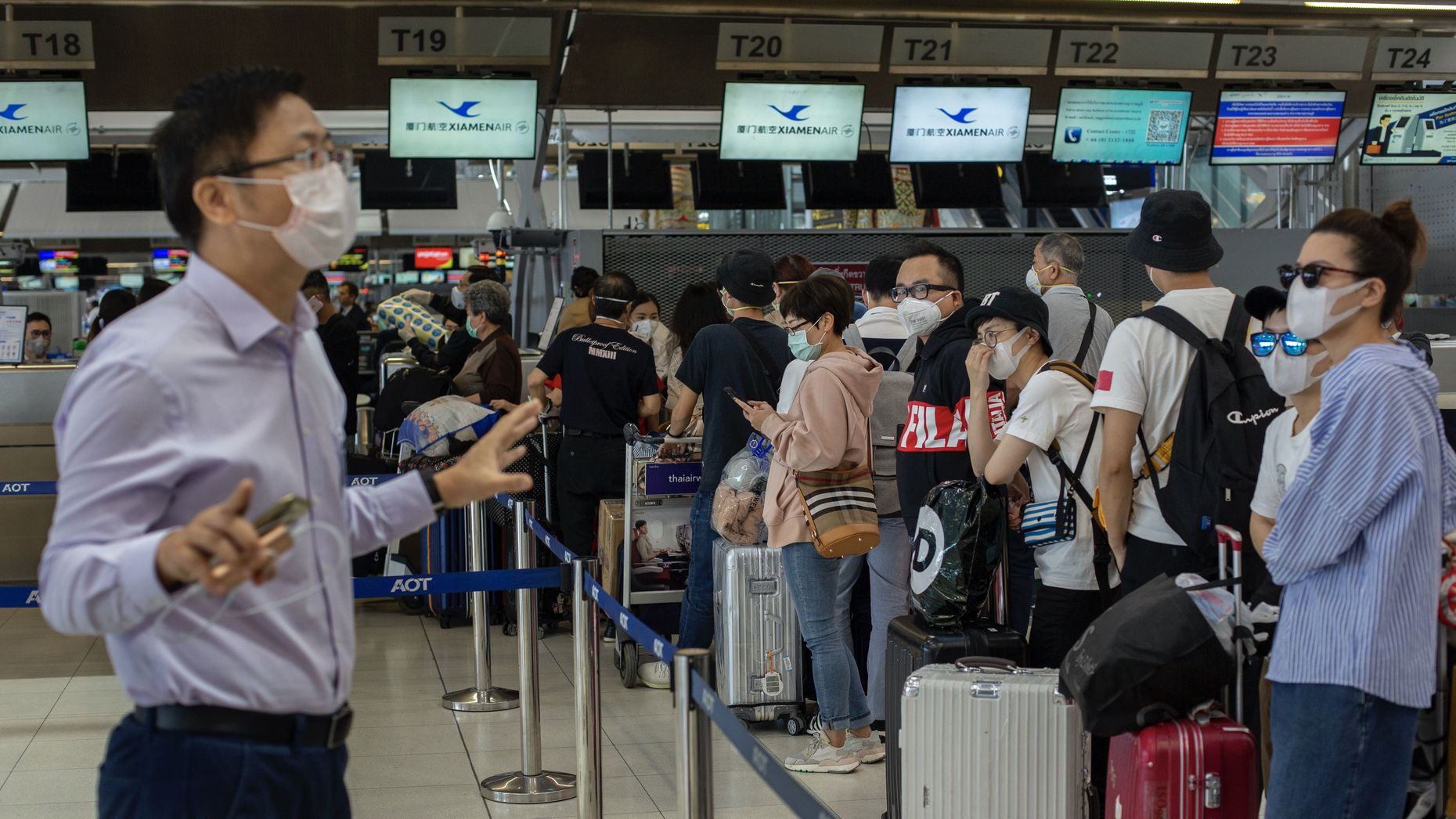 An airport official in Thailand talking to people flying to Wuhan this week. Photo by AP